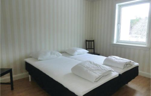 a bedroom with two beds with white sheets and a window at Lovely Home In Tranås With Kitchen in Bjärsjö