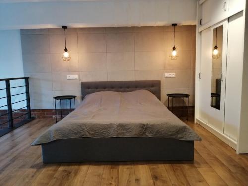a bedroom with a large bed and two tables at RedCity LOFT in Żyrardów