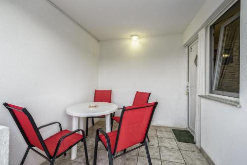 a room with a table and four red chairs at Apartments Marko in Vir
