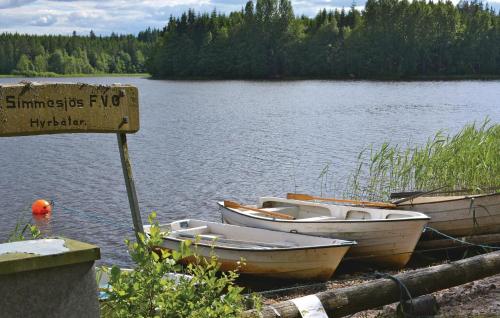 due barche sono ormeggiate sulla riva di un lago di 2 Bedroom Awesome Home In Lnghem a Åkra