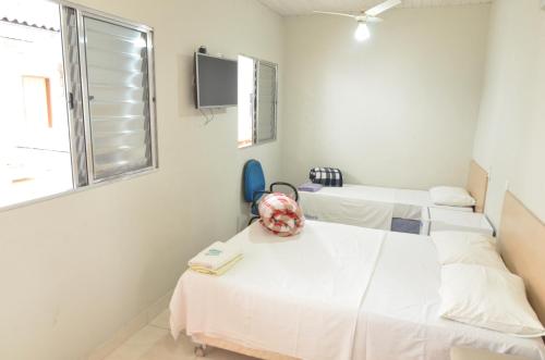 Habitación hospitalaria con 3 camas y ventana en HOTEL BEIRA RIO, en Ponte Nova