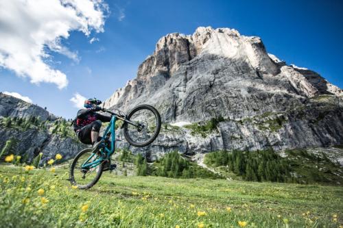 a person doing a trick on a bike in the mountains at Linder Cycling Hotel in Selva di Val Gardena