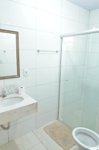 a bathroom with a shower and a toilet and a sink at HOTEL BEIRA RIO in Ponte Nova