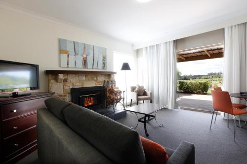 a living room with a couch and a fireplace at Harrigan's Hunter Valley in Pokolbin