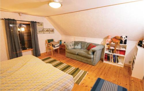 イースタッドにあるAmazing Home In Ystad With 2 Bedroomsのベッドルーム1室(ベッド1台、ソファ、椅子付)