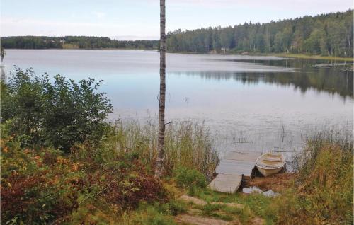 a boat sitting on the shore of a lake at Holiday Home Grums With Sea View I in Västra Malsjö