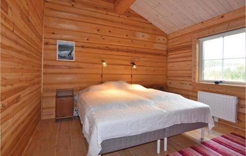 um quarto com uma cama num chalé de madeira em Nice Home In Grums With Kitchen em Västra Malsjö