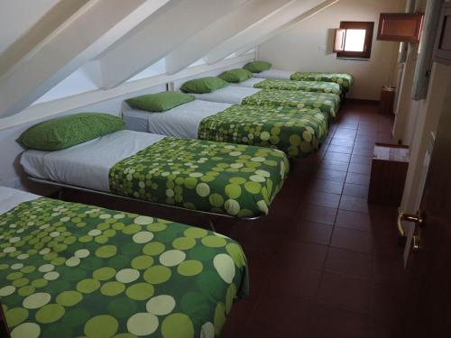 a row of beds lined up in a room at Rifugio Alpino Salvatore Citelli in Fornazzo