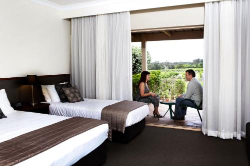 two people sitting on a balcony in a hotel room at Harrigan's Hunter Valley in Pokolbin
