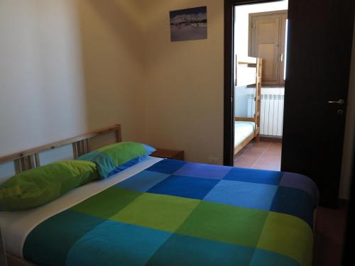 a bedroom with a bed with a colorful blanket at Rifugio Alpino Salvatore Citelli in Fornazzo