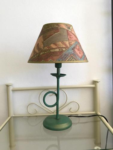 a green lamp with a shade on a table at Il Giardino Del Nespolo in Arcola