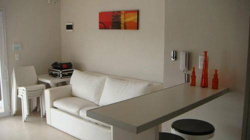 sala de estar con sofá blanco y mesa en Pinamar Alquilo Depto A 150 Mts Del Mar en Pinamar