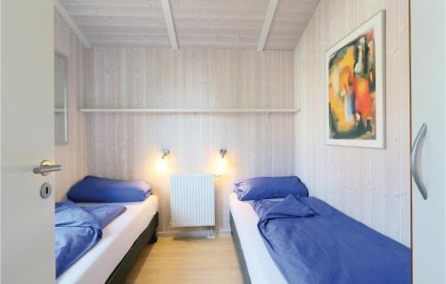 2 camas en una habitación con almohadas azules en Dnenpark 13 - Dorf 6, en Priwall