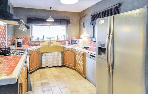 La cuisine est équipée d'un réfrigérateur et d'un évier. dans l'établissement Beautiful Home In Roujan With Wifi, à Roujan