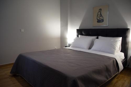 a bedroom with a large bed with a black headboard at Modern & Classy Central Apartment in Athens