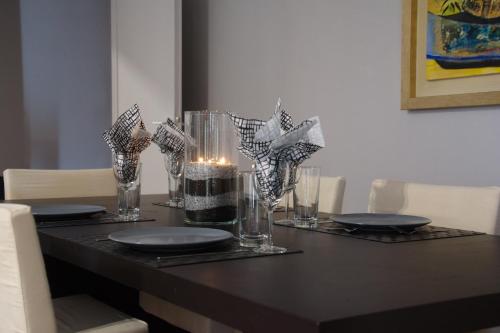 a table with plates and glasses and a candle on it at Modern & Classy Central Apartment in Athens