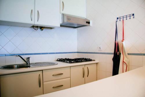 uma cozinha com um lavatório e um fogão em Panoramic Beach View Apartment (T2) in Caparica em Costa da Caparica