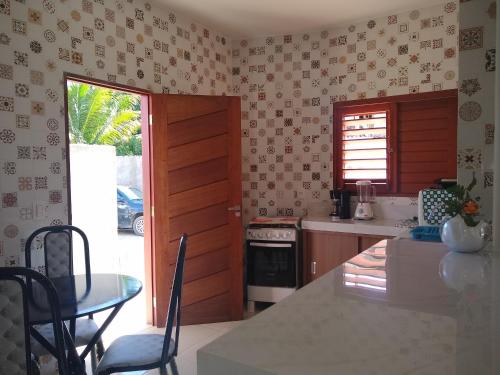 una cucina con tavolo e una sala da pranzo di Casa Carvalho Milagres a São Miguel dos Milagres