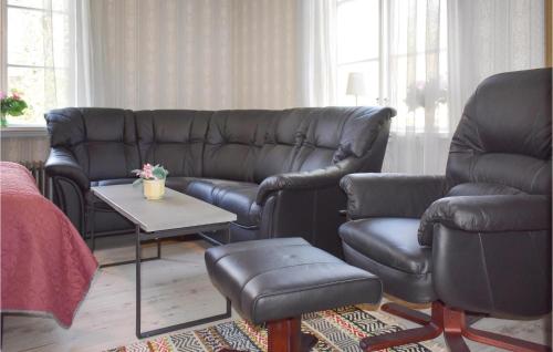 a living room with a leather couch and a chair at One-Bedroom Holiday Home In Virserum in Virserum