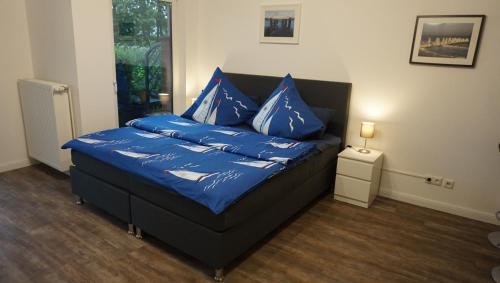 una cama con almohadas azules en una habitación en kuebo-ferien Wohnung 3 en Kühlungsborn