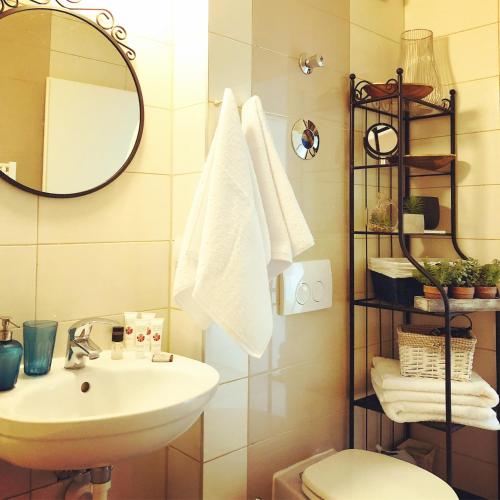 a bathroom with a sink and a toilet and a mirror at Belle View Apartment Brasov in Braşov