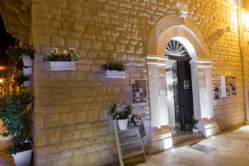 a building with potted plants on the side of it at BORGOBELTRANI in Trani