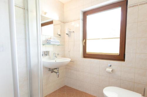 a bathroom with a sink and a toilet and a window at Haus Steinbock in Neustift im Stubaital