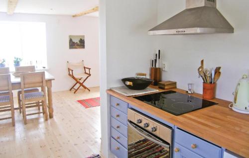 a kitchen with a stove top oven next to a table at Holiday Home Fiskarevägen Abbekås Ii in Abbekås