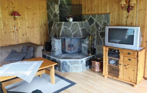 a living room with a stone fireplace and a tv at Stunning Home In Olden With Kitchen in Olden