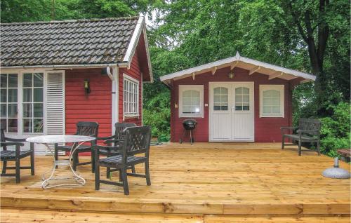 イースタッドにある2 Bedroom Lovely Home In Ystadの小さな赤い家(木製デッキにテーブルと椅子付)