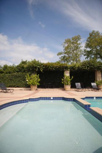 a swimming pool in a yard with chairs and trees at Harrigan's Hunter Valley in Pokolbin