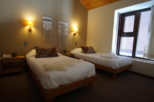 a room with two beds and a window at Colorado Apart Hotel in El Colorado