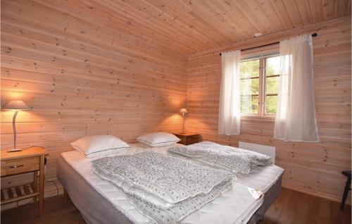 a bedroom with a bed in a wooden wall at Beautiful Home In rjng With 3 Bedrooms And Wifi in Årjäng