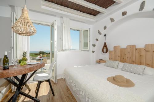 a bedroom with a bed and a table with a hat on it at Naxos Island Escape Suites in Plaka
