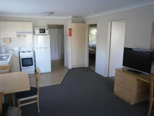 a kitchen with a white refrigerator and a counter top at George Bass Motor Inn in Nowra