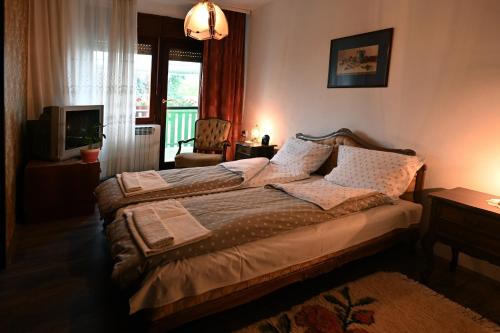 1 dormitorio con 1 cama, TV y ventana en Kikinda peace oaza, en Kikinda
