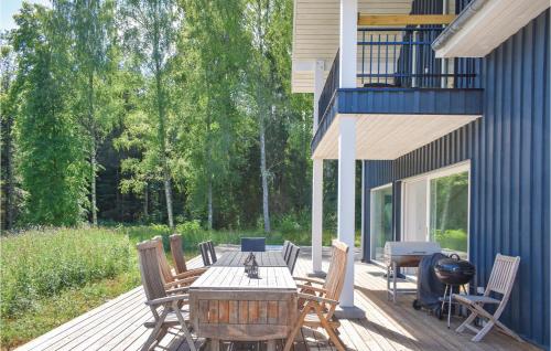 a wooden deck with a table and chairs on it at Stunning Home In Tingsryd With Kitchen in Tingsryd