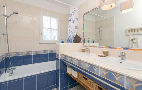 a bathroom with two sinks and a mirror at Le Domaine De Vertmarines in Saint-Jean-de-Monts