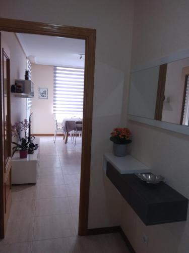 a bathroom with a sink and a dining room at Apartamento playa Samil in Vigo