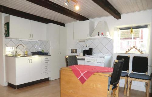 a kitchen with white cabinets and a table in a room at Stunning Home In Tomelilla With Wifi in Bollerup