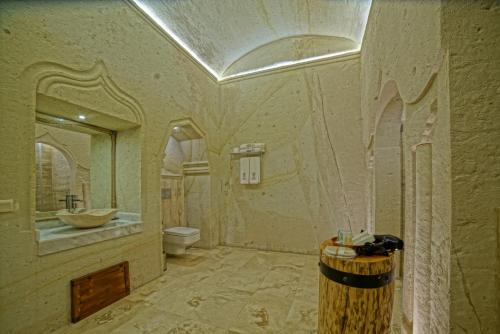a large bathroom with a sink and a toilet at Taru Cave Suites in Urgup