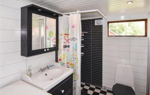a bathroom with a sink and a shower curtain at 2 Bedroom Stunning Home In Strmstad in Lommeland