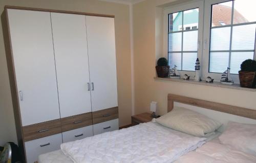 ein Schlafzimmer mit einem Bett und einem großen weißen Schrank in der Unterkunft Nice Apartment In Insel Poel-gollwitz With 1 Bedrooms in Gollwitz
