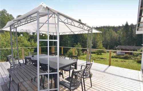 a pavilion with a table and chairs on a deck at 2 Bedroom Stunning Home In Strömstad in Lommeland