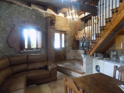 sala de estar con sofá, mesa y cocina en Casa Rural Generoso, en Madroñal