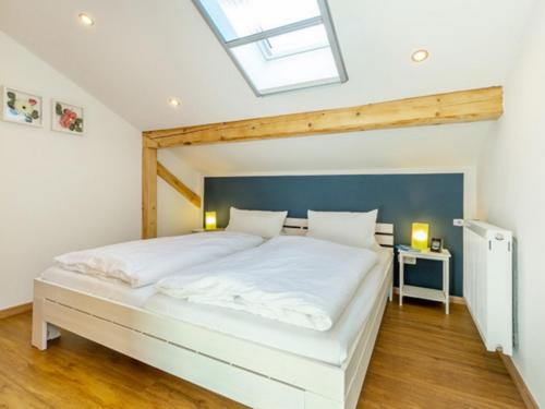 Schlafzimmer mit einem großen weißen Bett und einem Dachfenster in der Unterkunft Ferienwohnung Auszeit in Grassau