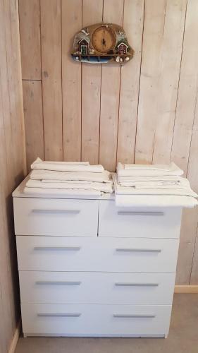 two white dressers in a room with a wall at Farmer Apartment in Laukvik