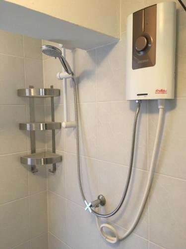 y baño con ducha y cabezal de ducha. en Beach Apartment Samui (Bann Kanchana Bangrak), en Bophut 