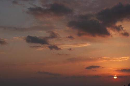 a cloudy sky with the sun in the background at Frini Studios in Plomarion