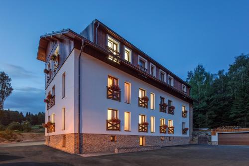 Un gran edificio blanco con ventanas y balcones. en Apartmány Anička, en Železná Ruda